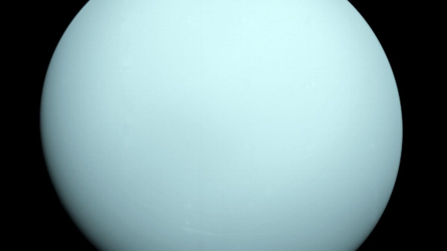 NASA's Voyager 2 false-color image of Uranus, taken during the spacecraft's single 1986 flyby, showing the featureless pale cyan disk that gave the planet its reputation as the solar system's blandest world